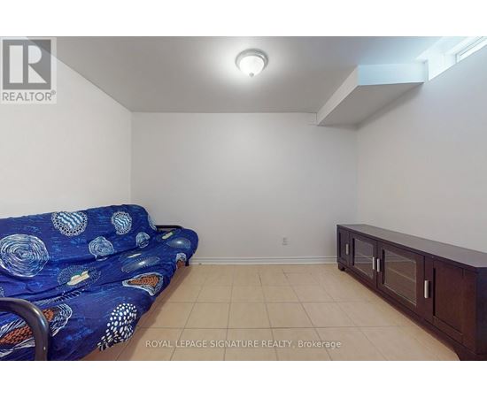A living room with a blue patterned couch and a wooden cabinet.