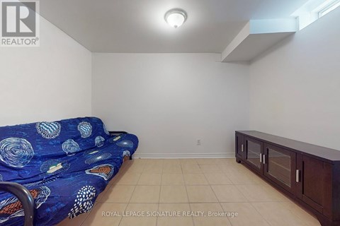 A living room with a blue patterned couch and a wooden cabinet.