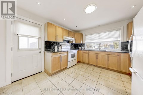 A kitchen with wooden cabinets and a white door.