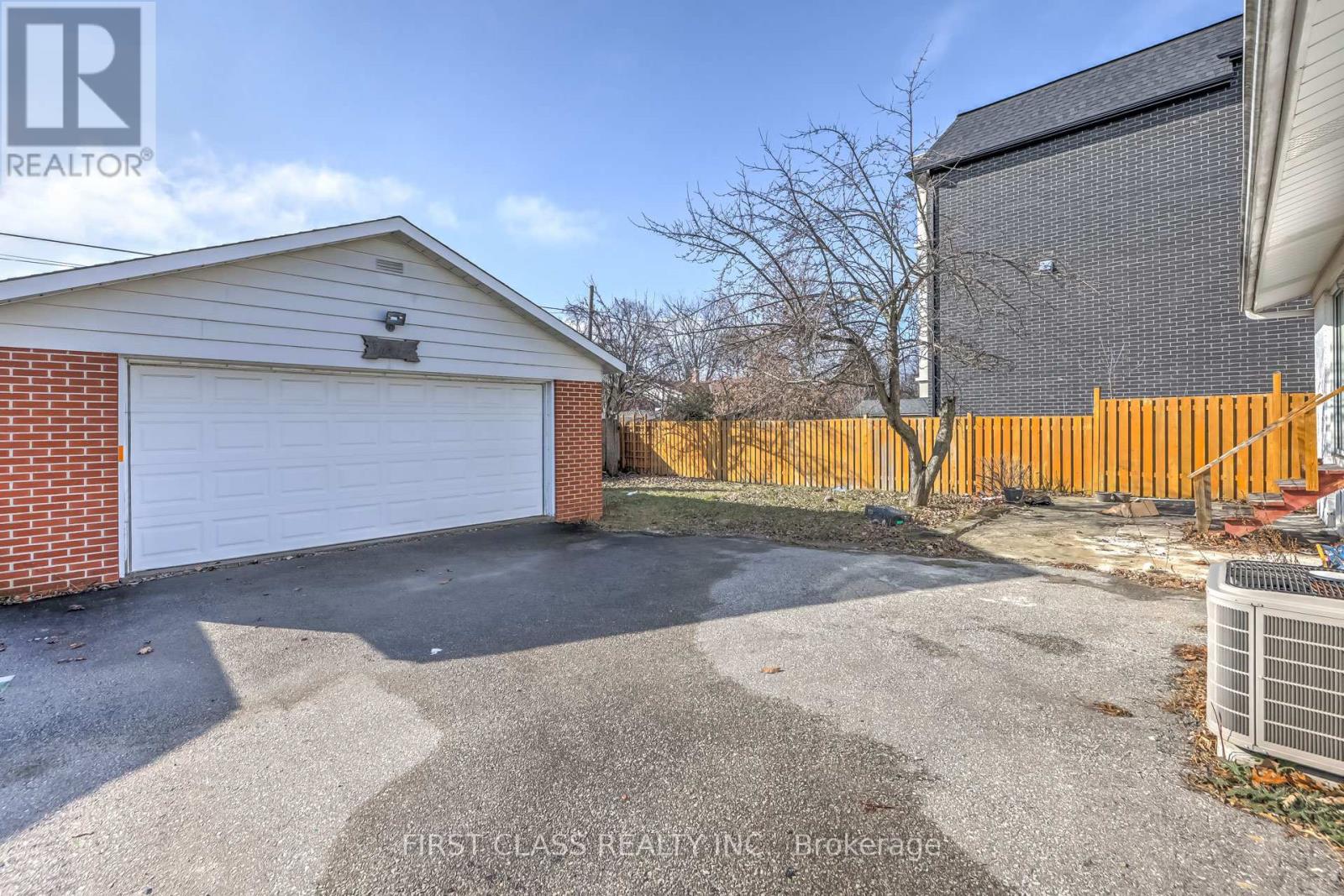 A garage with a white door is situated in front of a brick building.