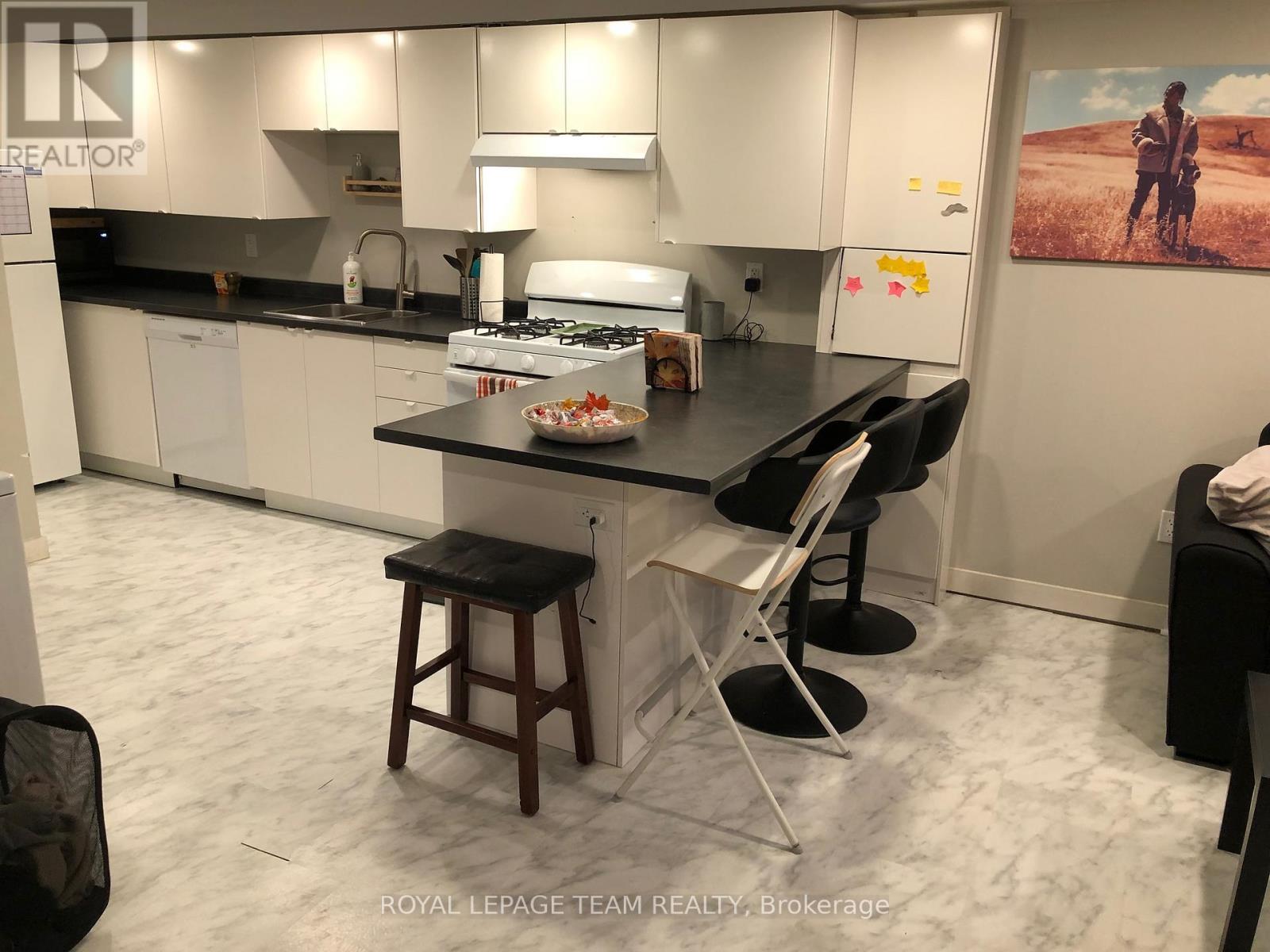 A kitchen with a table and chairs in front of it.