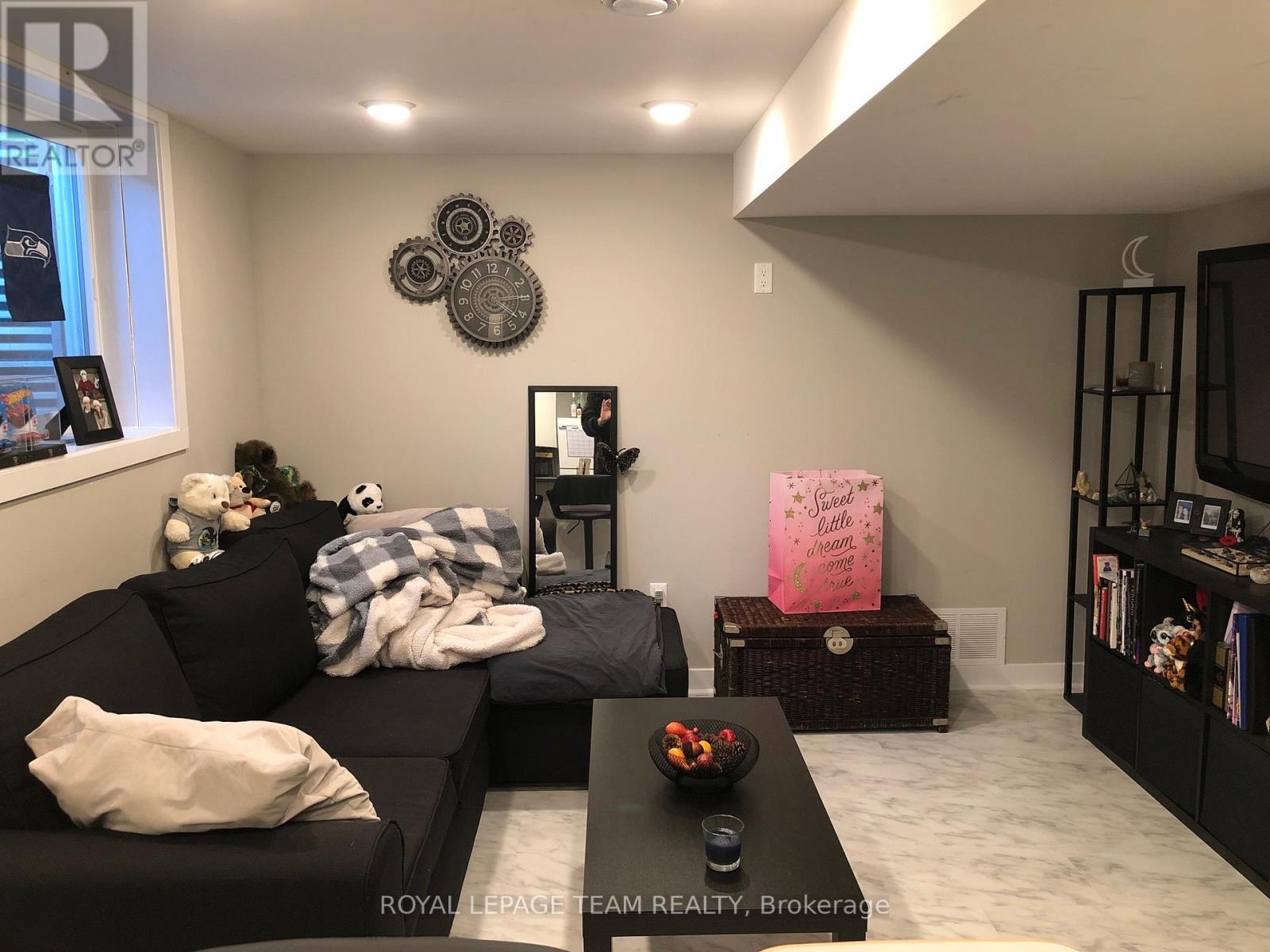 A living room with a black couch, a coffee table, and a pink box on a side table.
