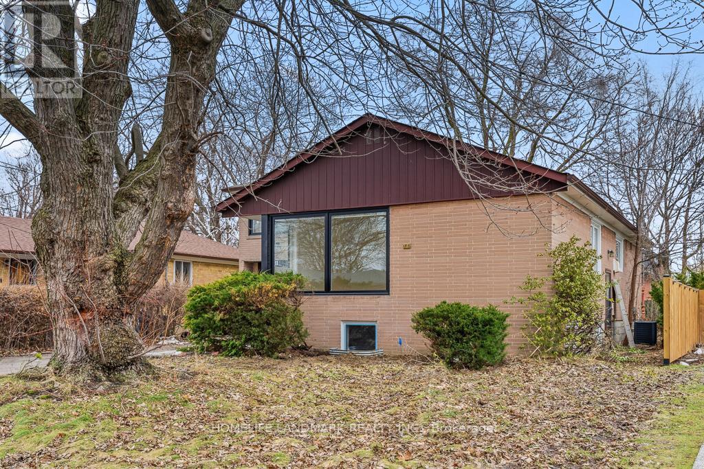 A house with a brown roof and a tree in front.