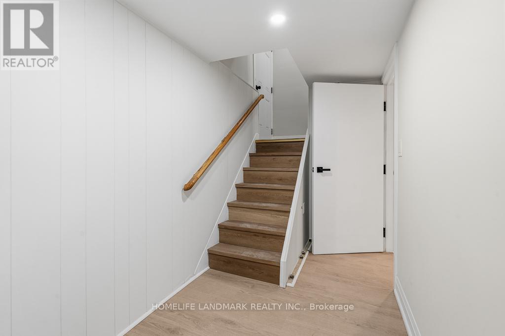 A hallway with a staircase and a door.