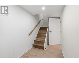 A hallway with a staircase and a door.