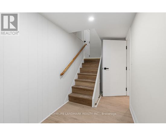 A hallway with a staircase and a door.