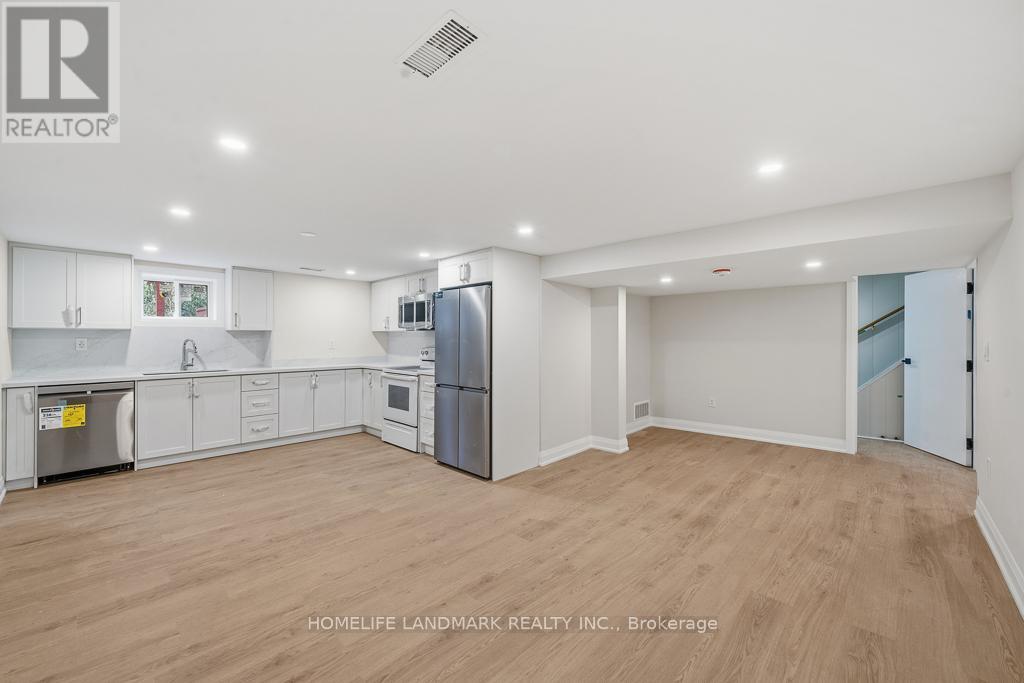 A spacious kitchen with white cabinets and a refrigerator.