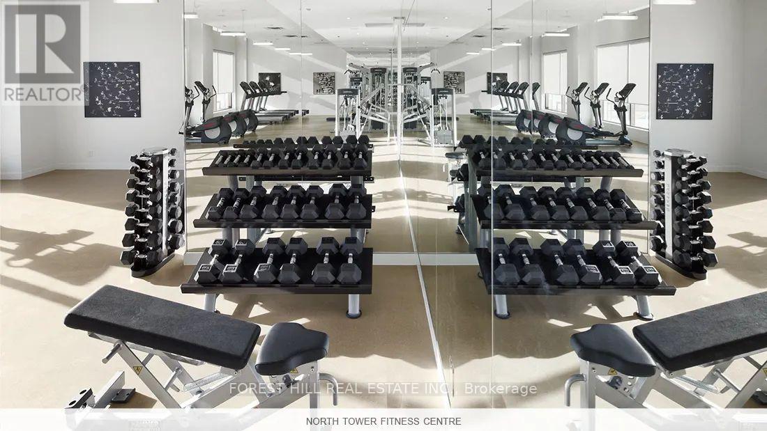 A gym with a variety of equipment including dumbbells and benches.
