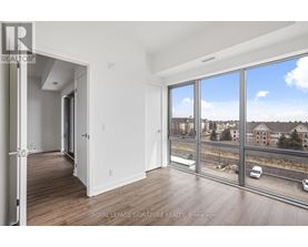 A room with a view of a highway and buildings outside the window.