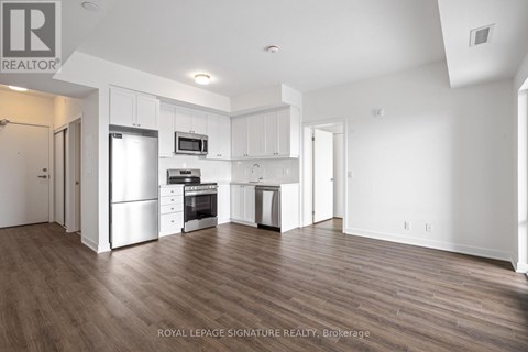 A spacious kitchen with white cabinets and stainless steel appliances.
