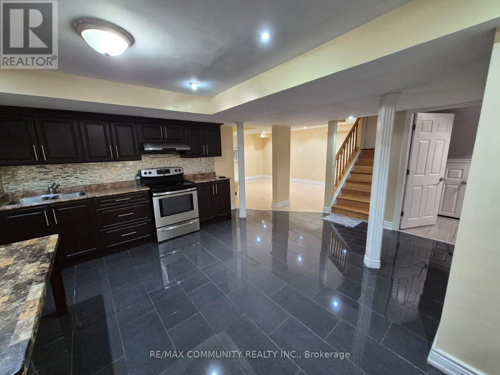 A kitchen with black cabinets and a stone countertop.