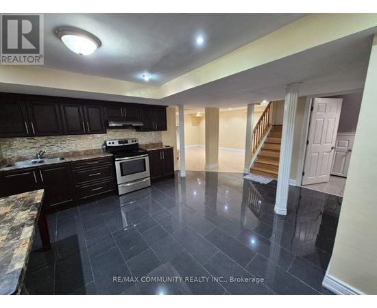 A kitchen with black cabinets and a stone countertop.