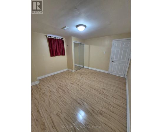 A room with a wooden floor and a white door.