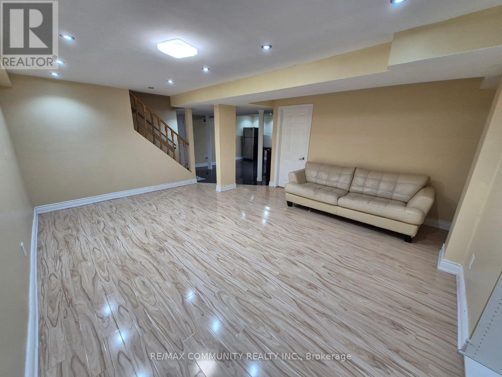 A living room with a couch and a staircase.