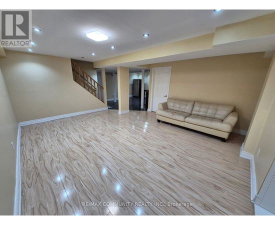 A living room with a couch and a staircase.