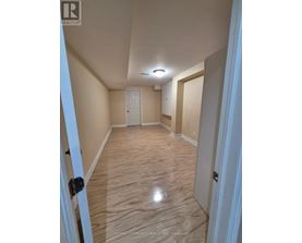A hallway with wood flooring and white doors.