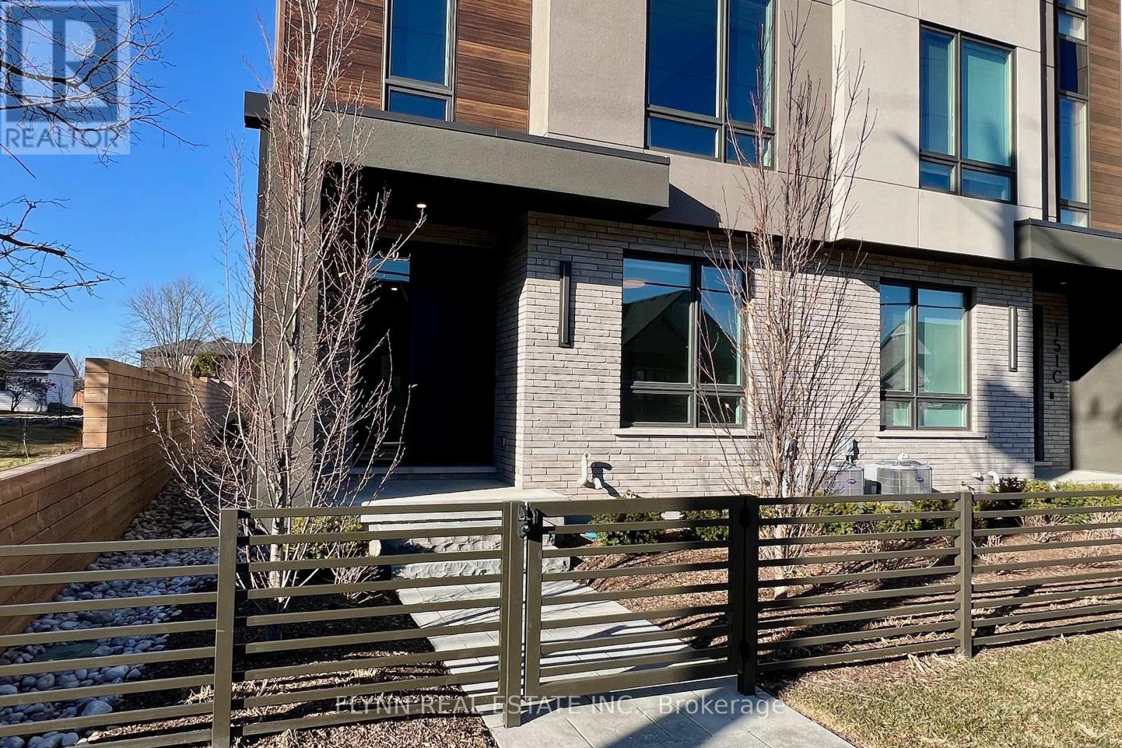 A modern house with a wooden fence in front.