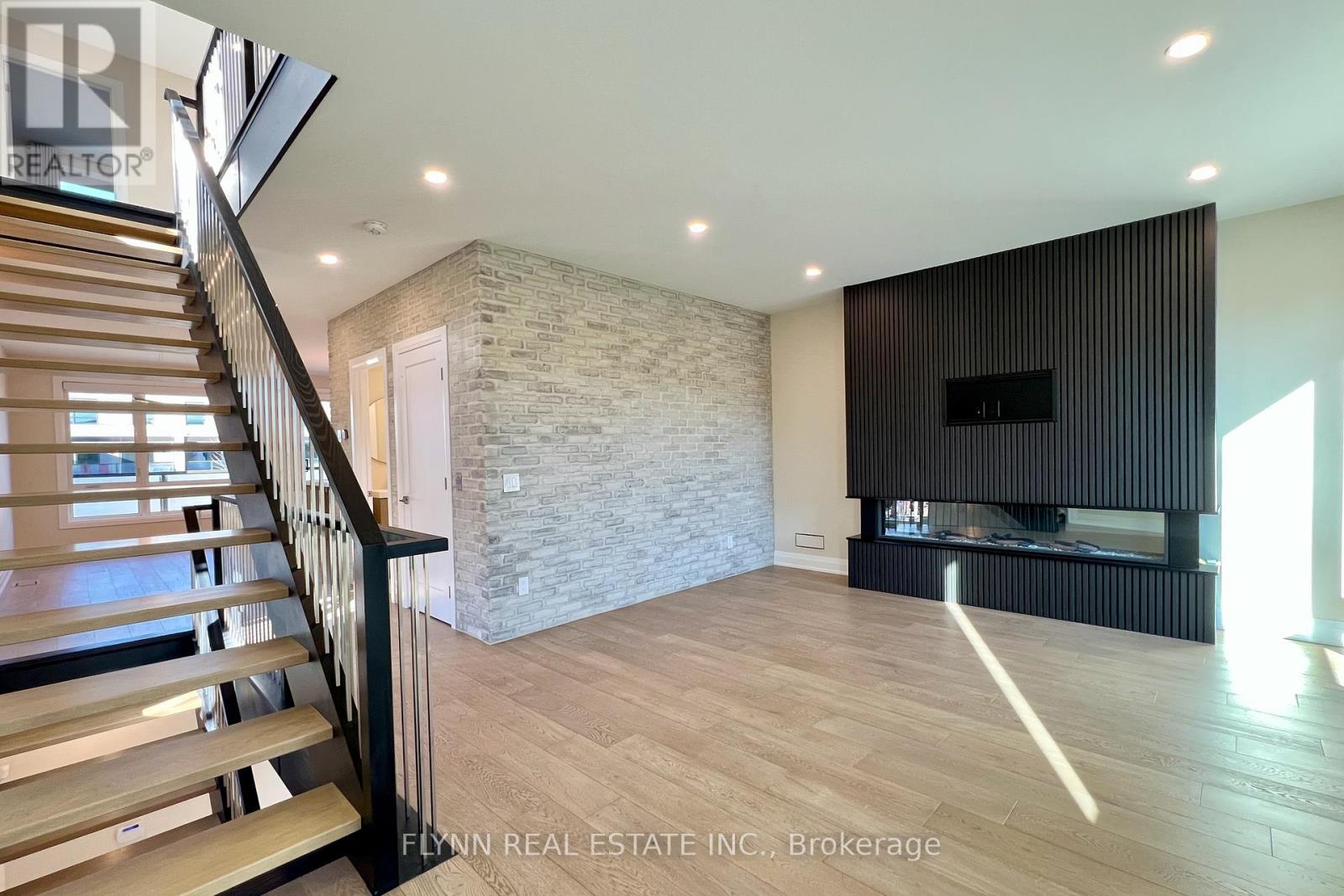 A spacious living room with a stone wall and a fireplace.