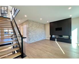 A spacious living room with a stone wall and a fireplace.