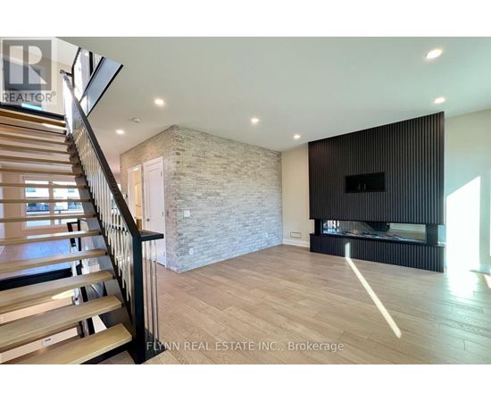 A spacious living room with a stone wall and a fireplace.