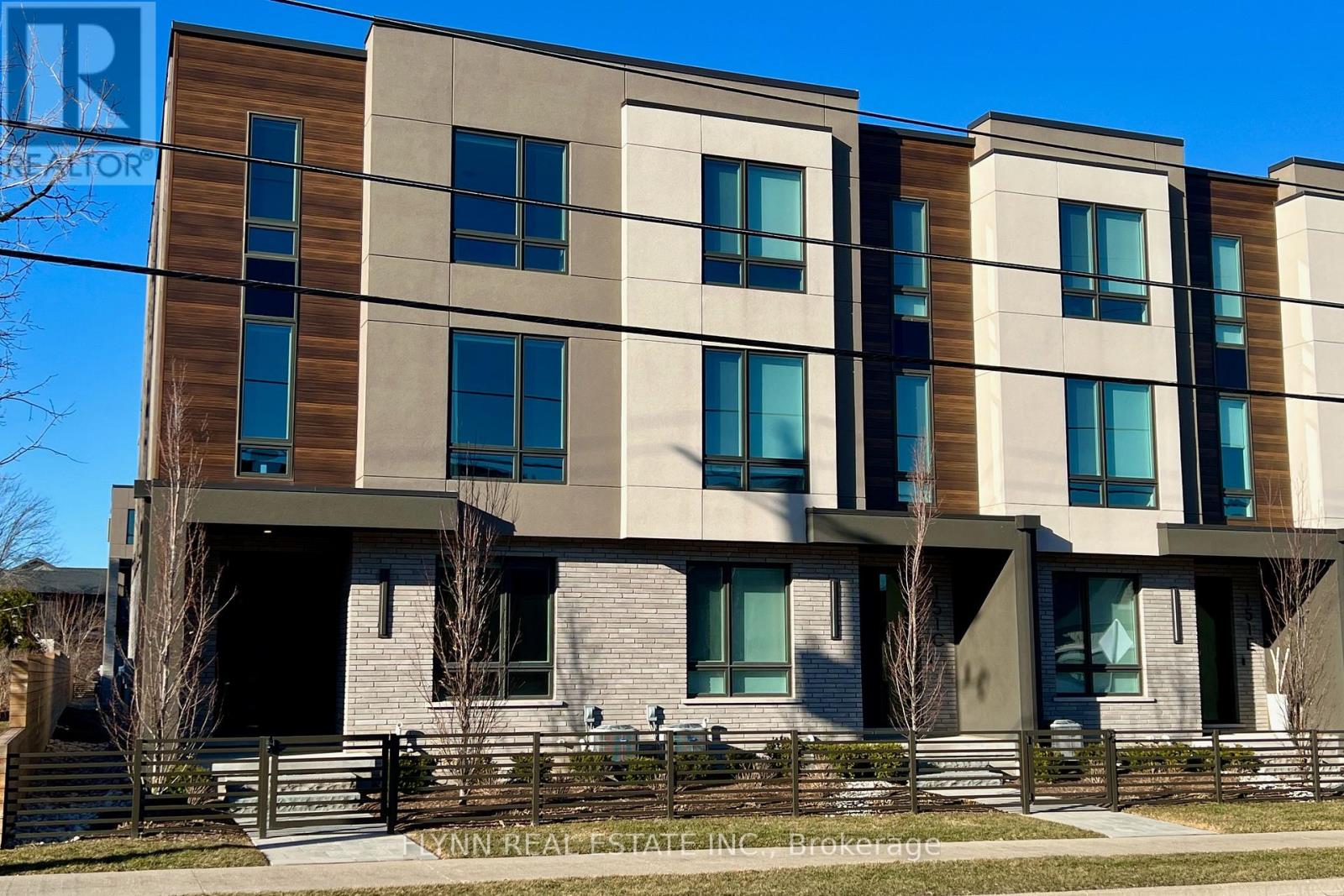 A modern building with a brown and beige facade and multiple windows.