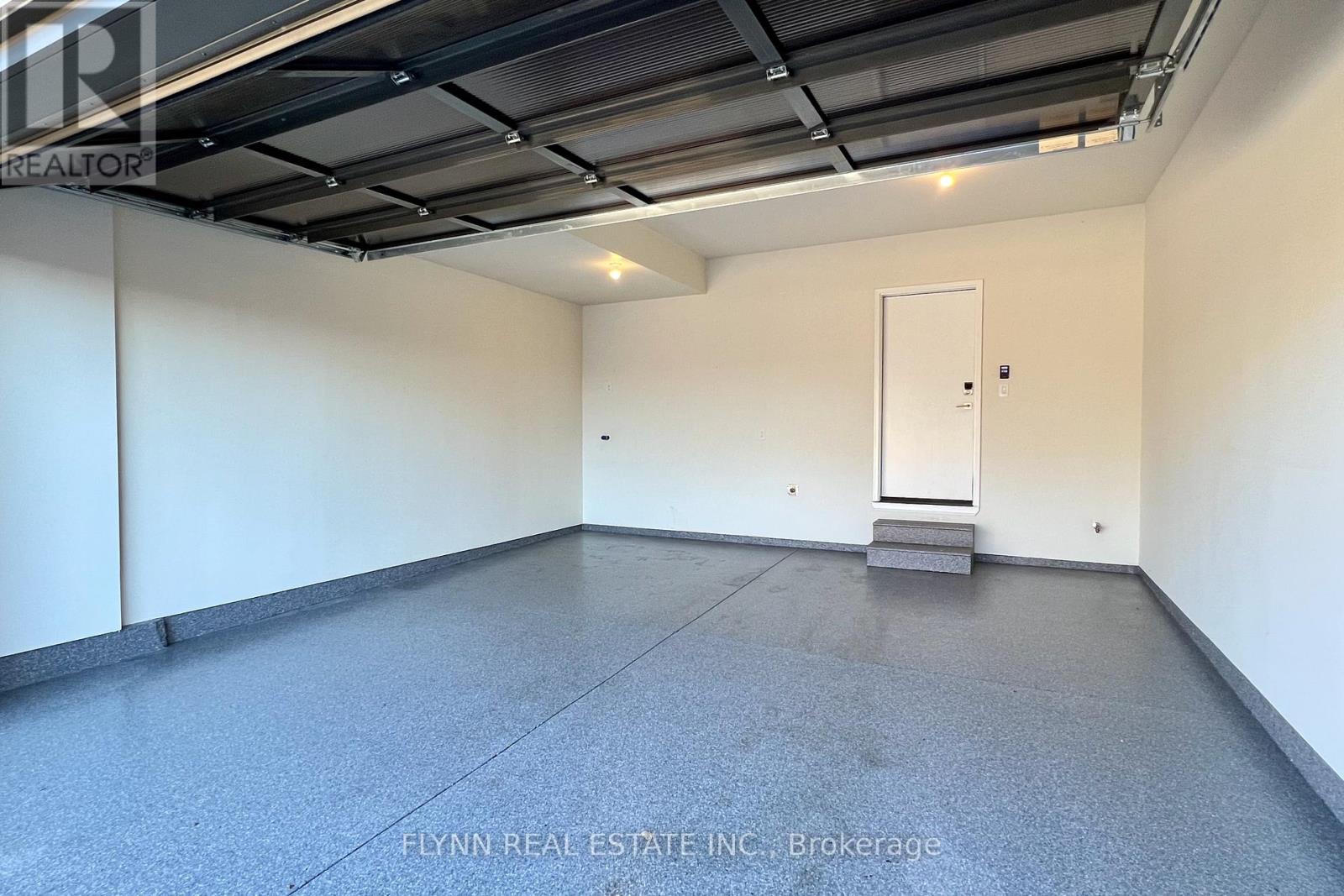 A spacious room with a concrete floor and a white door.