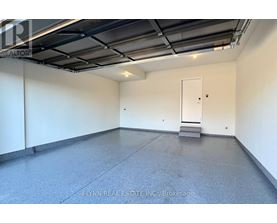 A spacious room with a concrete floor and a white door.