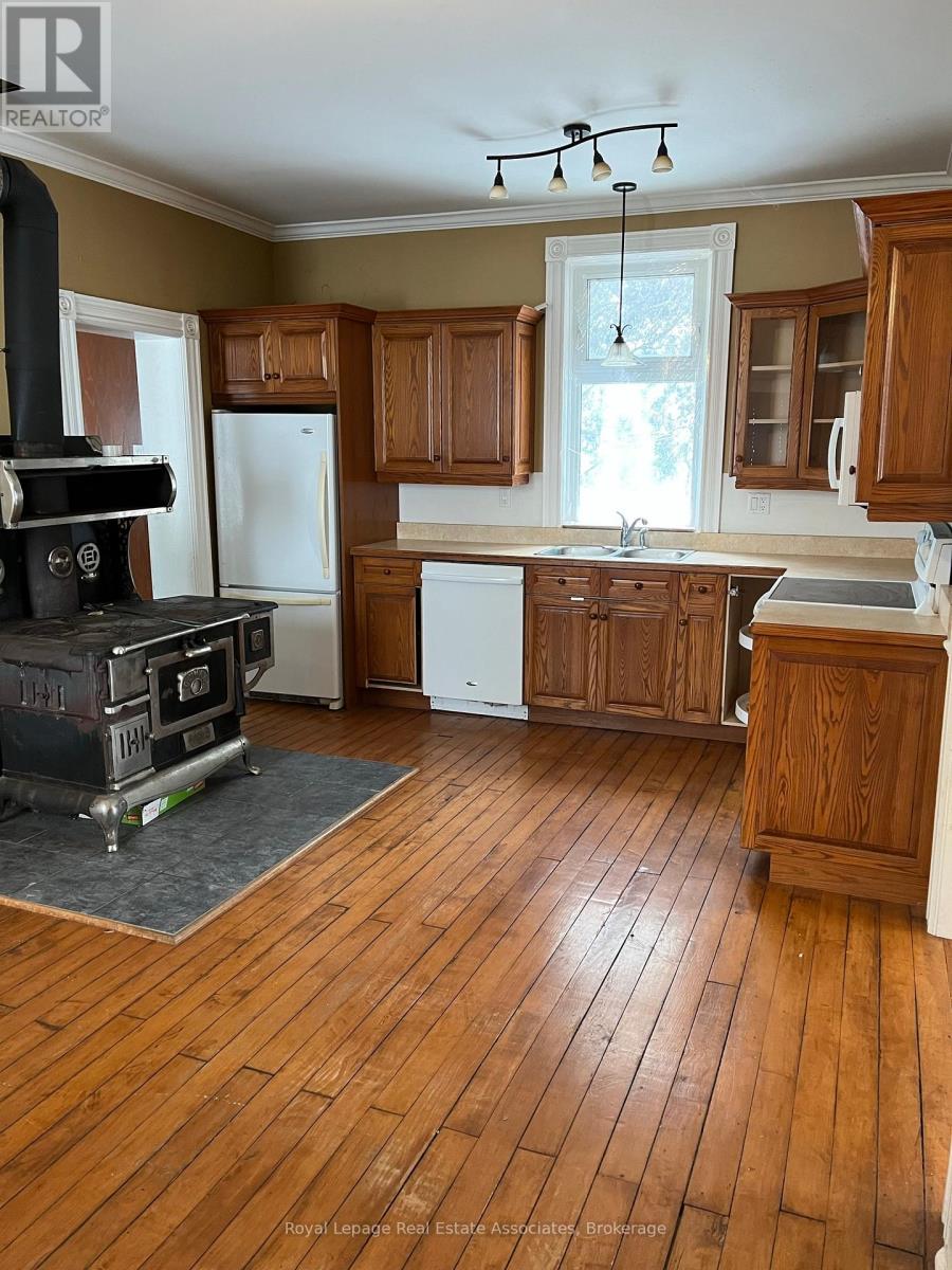 A kitchen with wood floors and a wood stove.