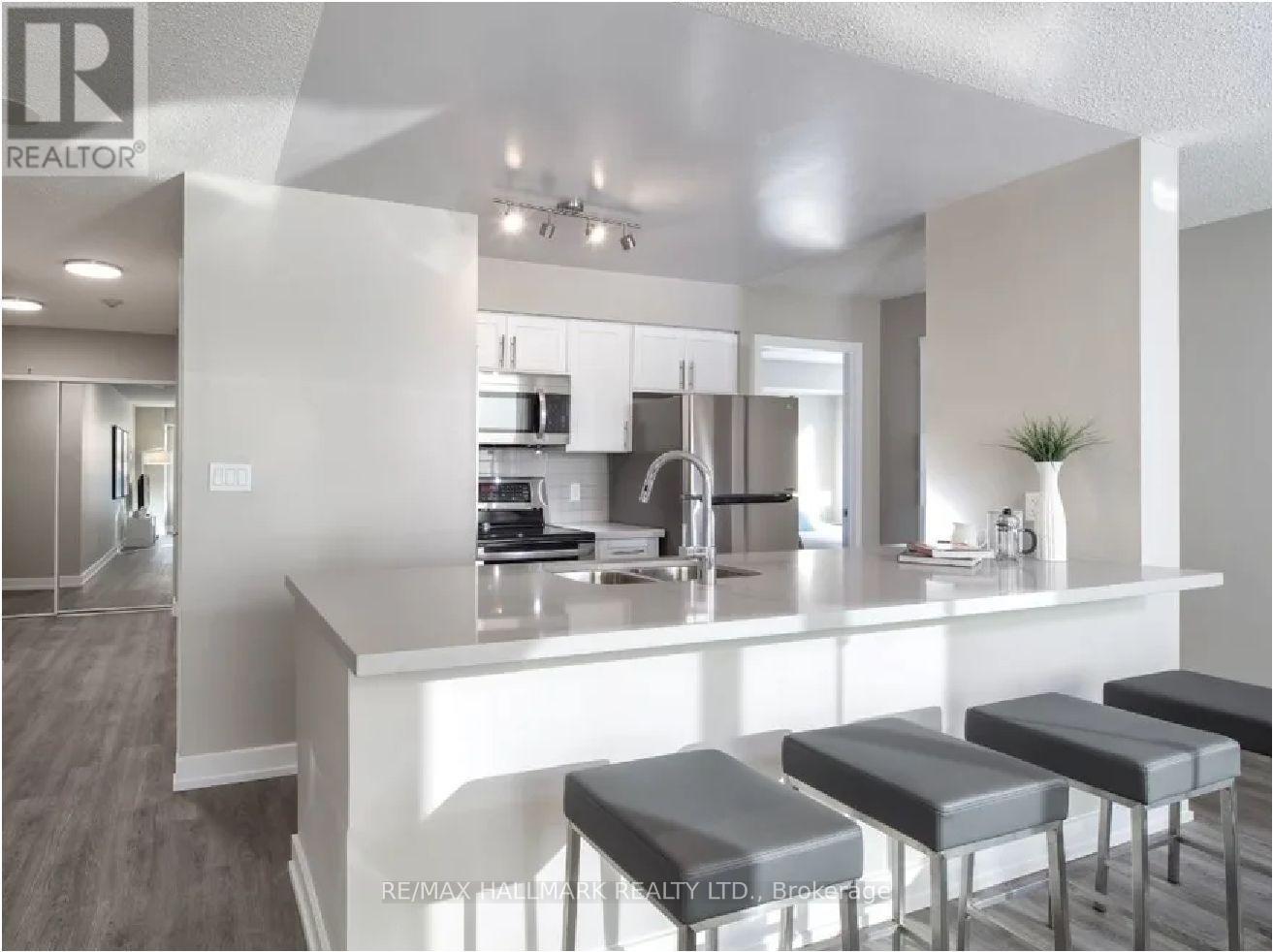 A modern kitchen with a bar stool in front of the island.