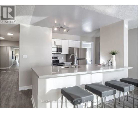 A modern kitchen with a bar stool in front of the island.