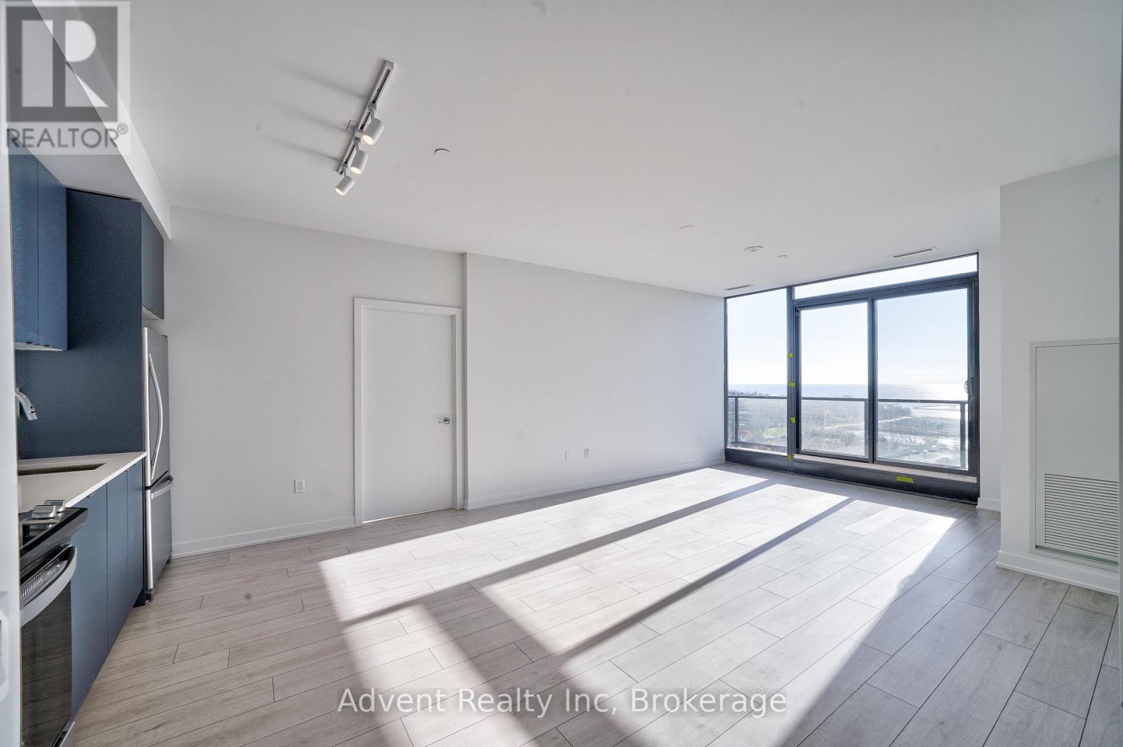 A spacious, empty room with a view of the city through large windows.