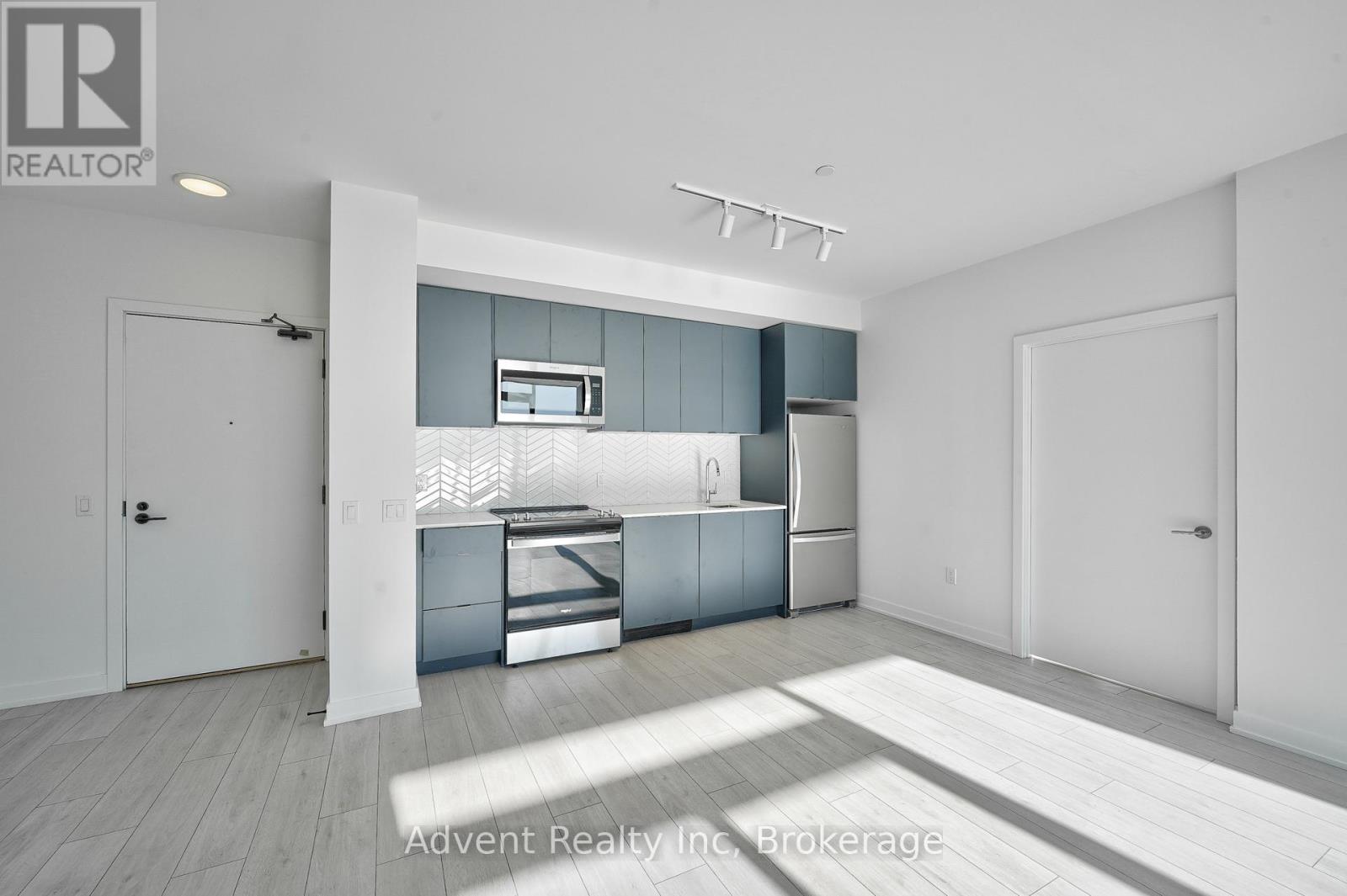 A modern kitchen with white cabinets and a white fridge.