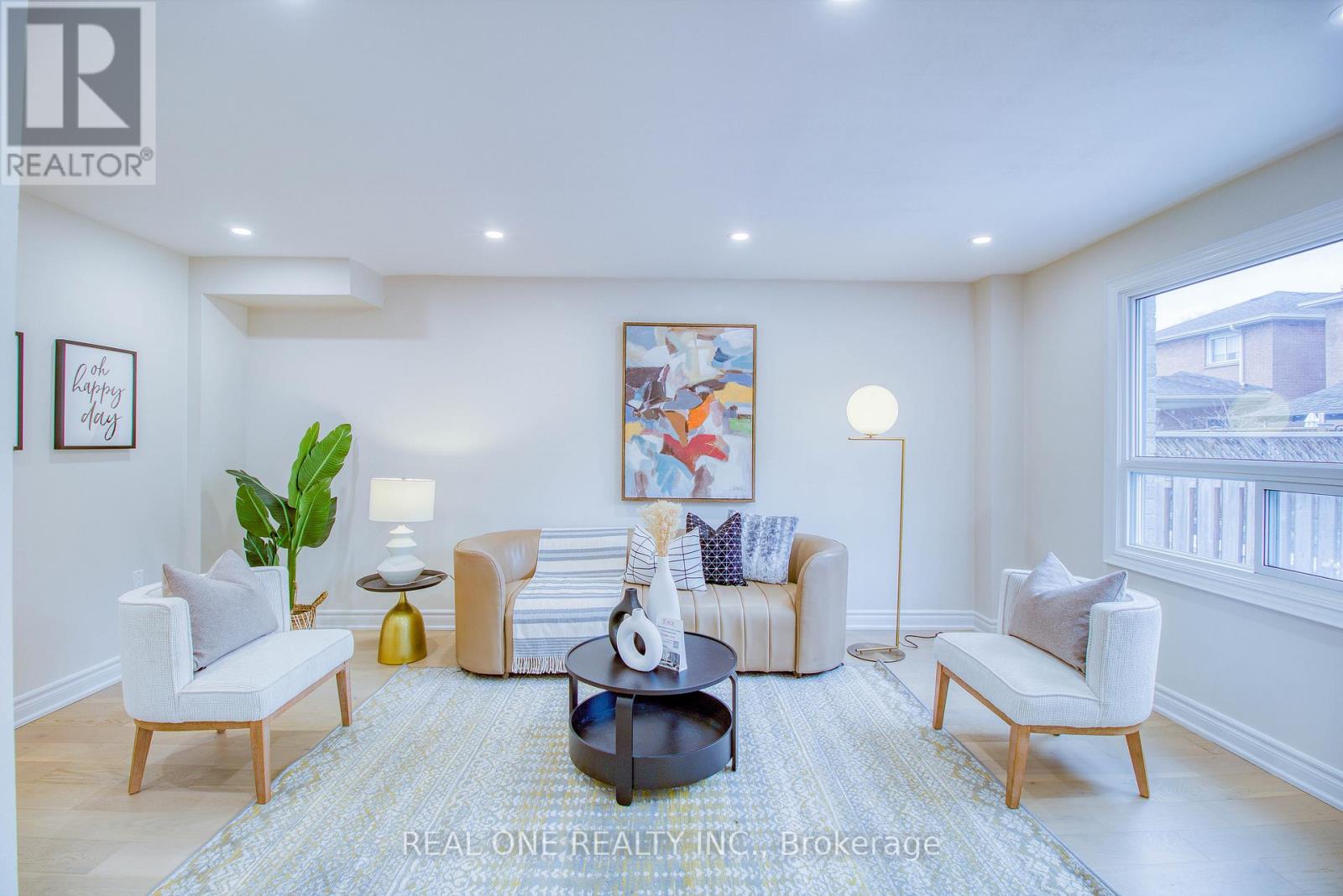 A well-lit living room with a large painting on the wall and a coffee table in the center.