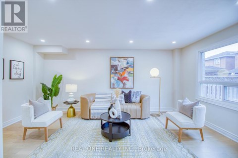 A well-lit living room with a large painting on the wall and a coffee table in the center.