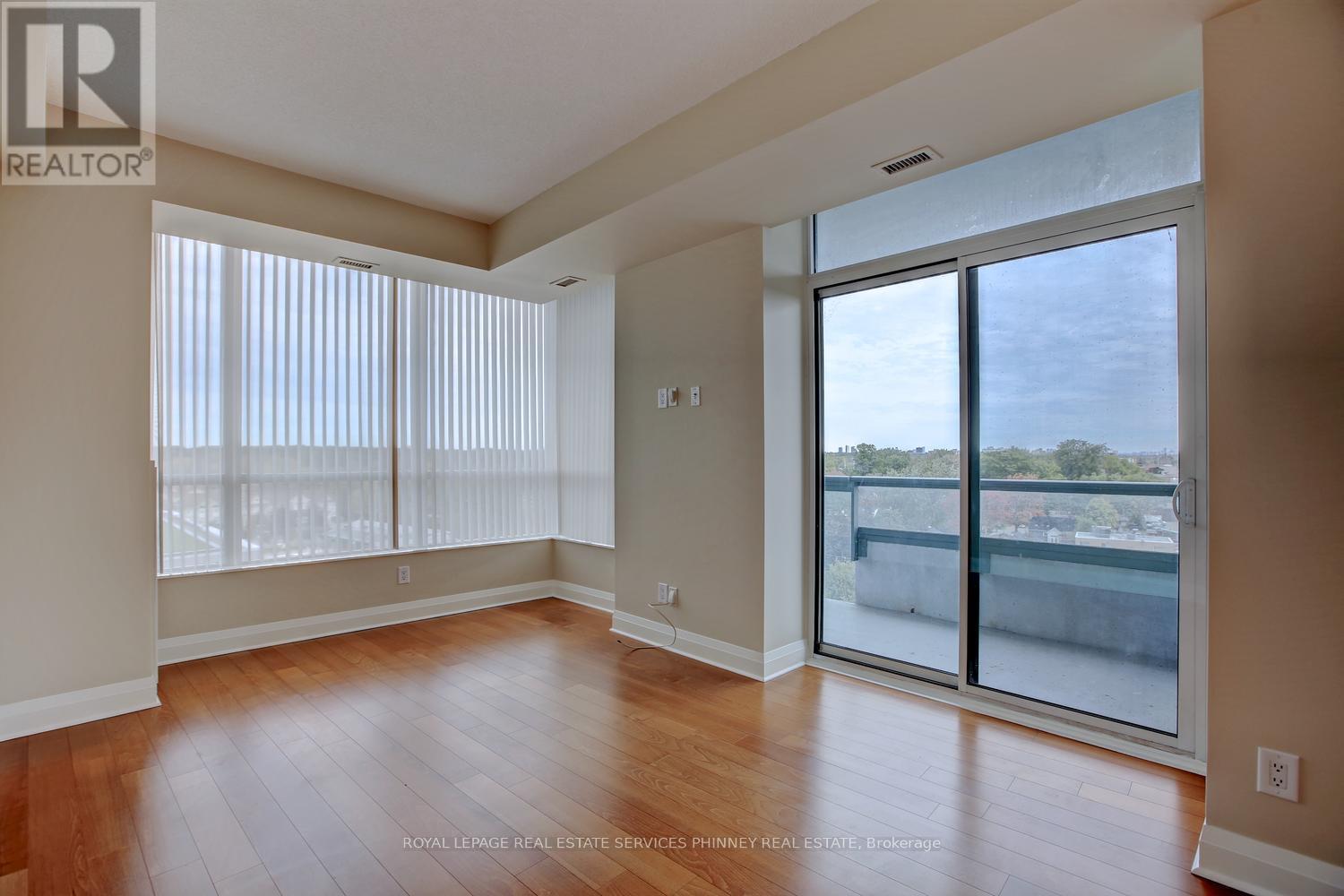 A spacious room with wooden floors and sliding glass doors.