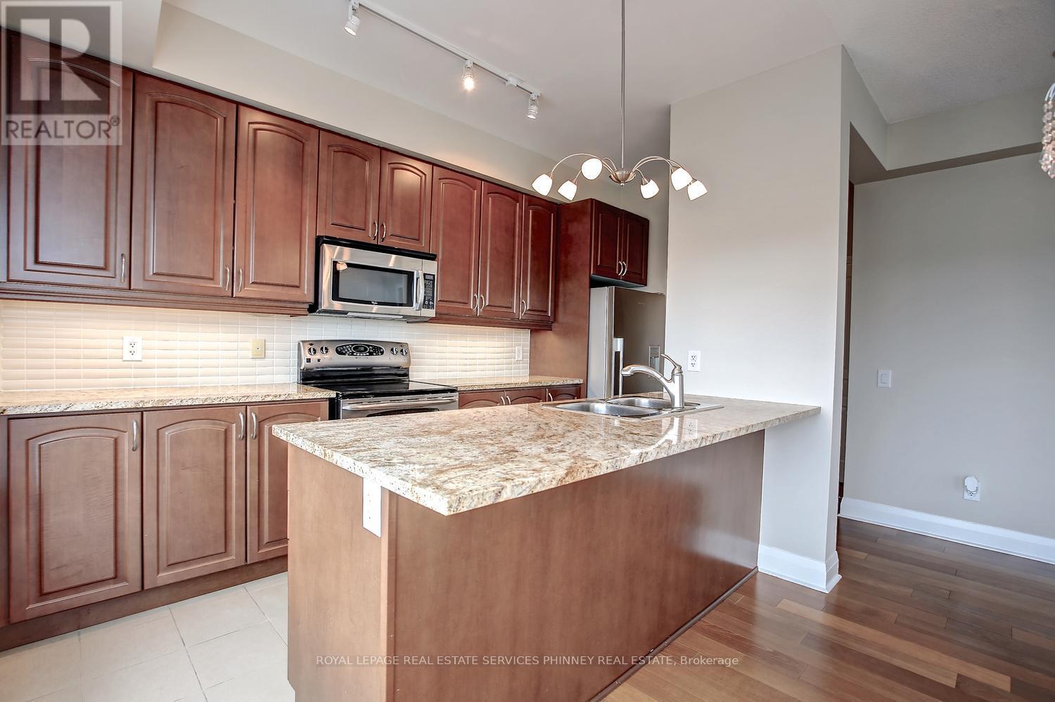 A kitchen with brown cabinets and a granite countertop.