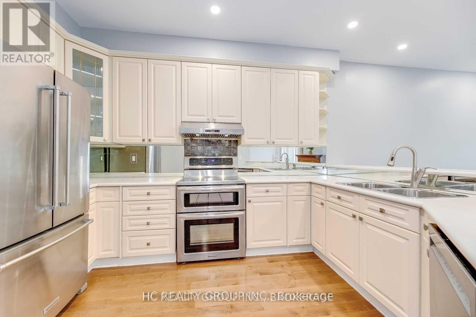 A kitchen with white cabinets and stainless steel appliances.