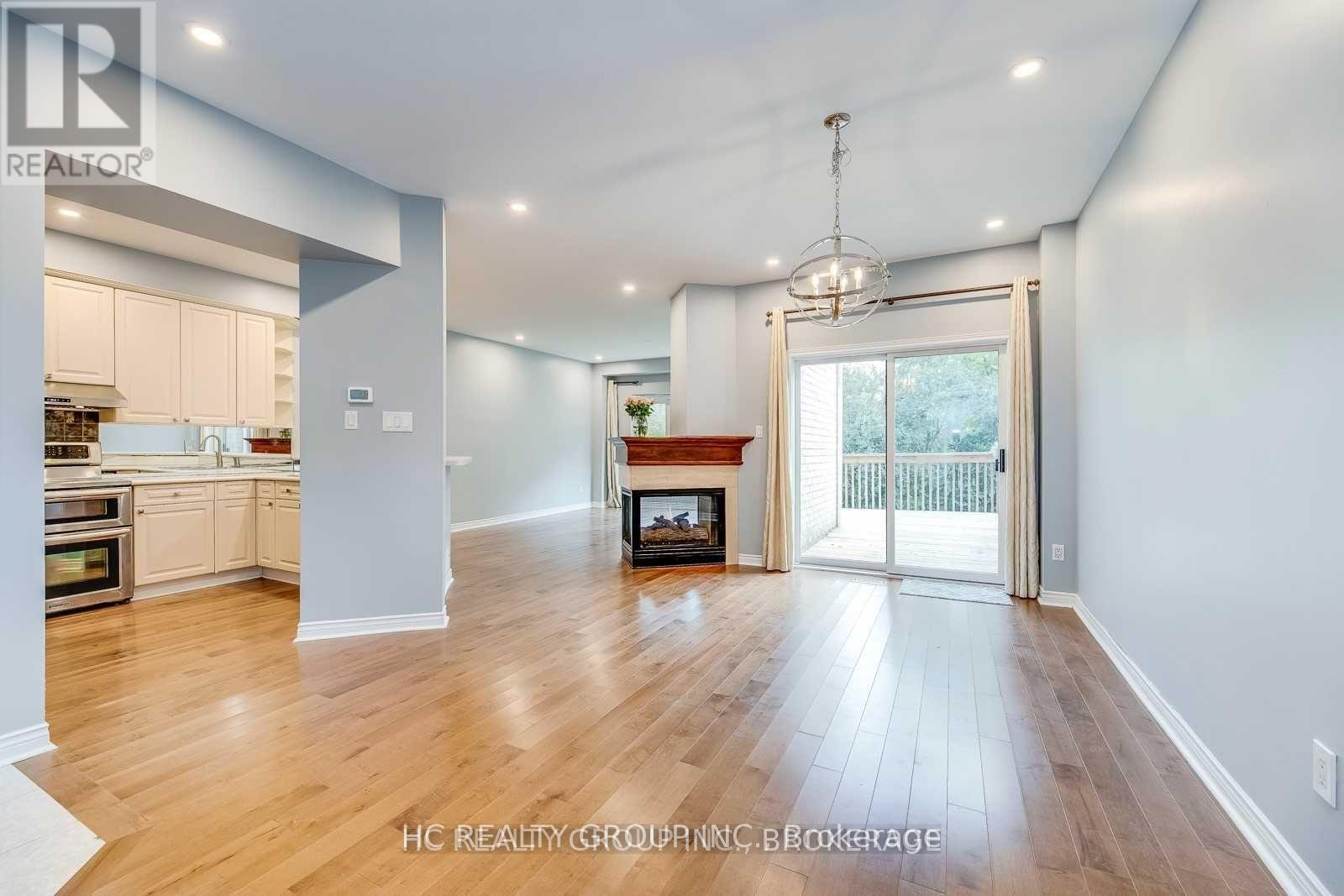 A spacious living room with a fireplace and sliding glass doors leading to a balcony.