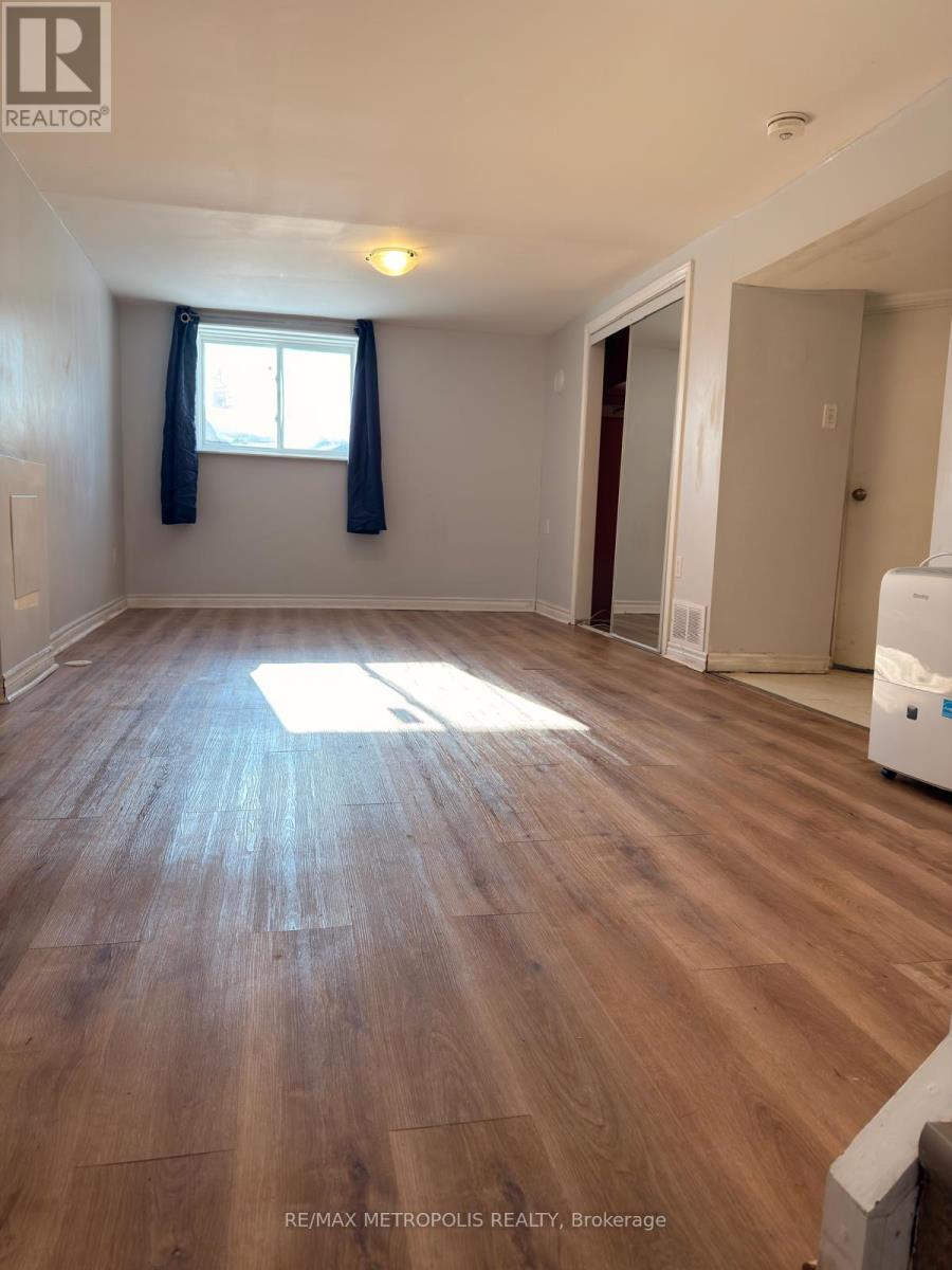 A room with wooden flooring and a window with blue curtains.