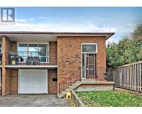 A two-story brick house with a garage and a balcony on the second floor.
