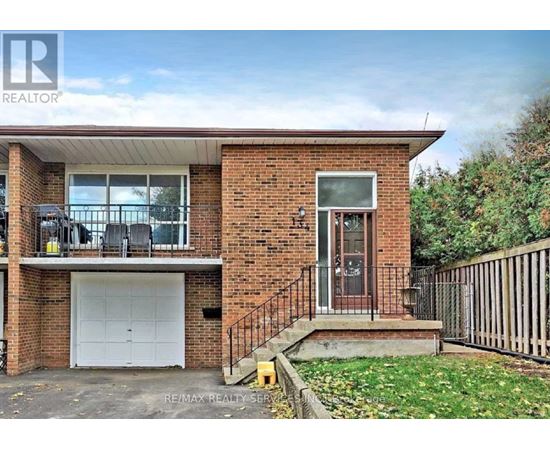 A two-story brick house with a garage and a balcony on the second floor.