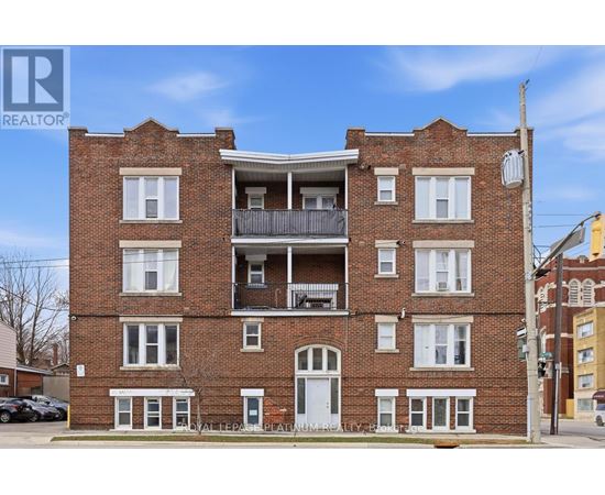A red brick building with a balcony on the second floor.