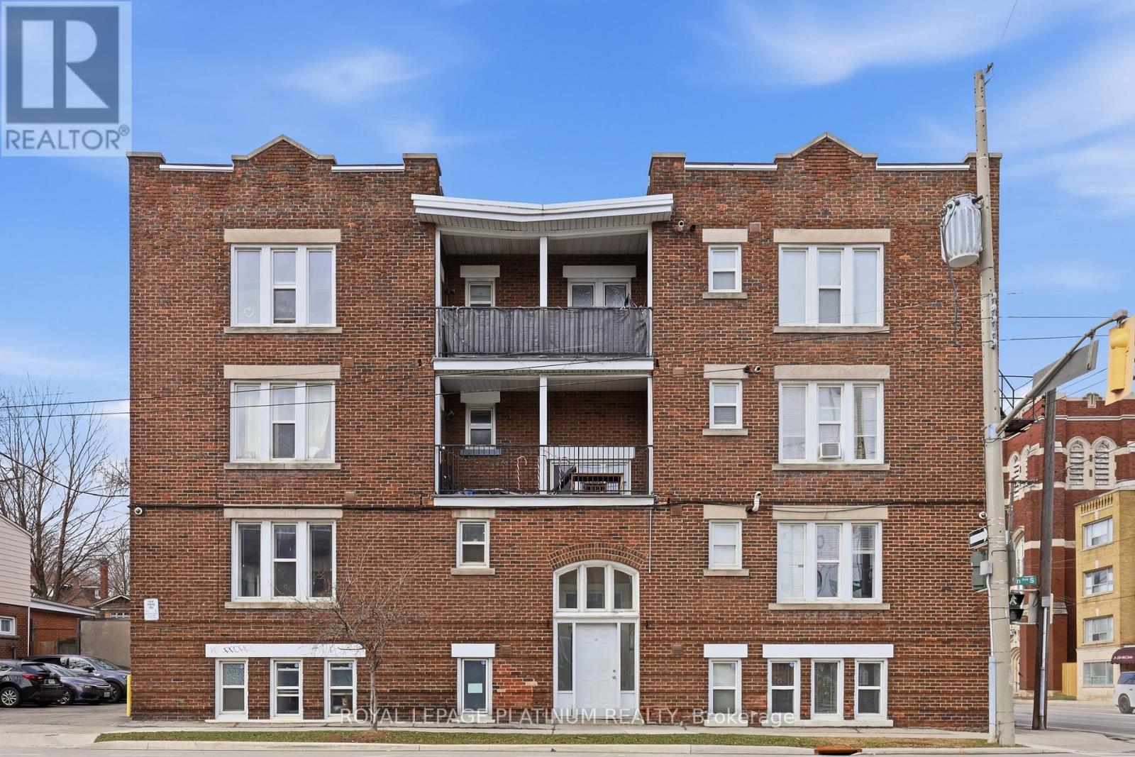 A red brick building with a balcony on the second floor.
