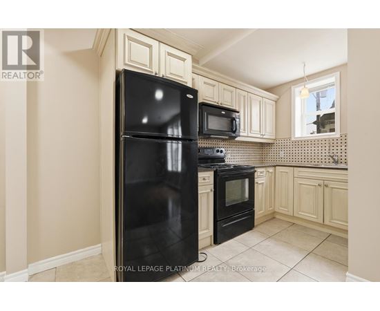 A kitchen with a black fridge and microwave.