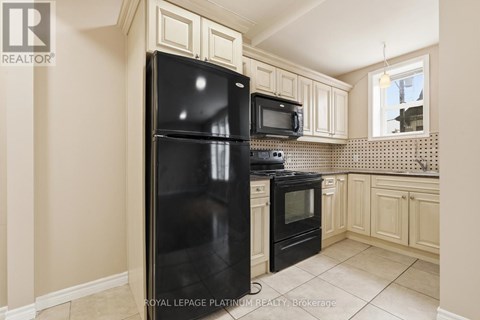 A kitchen with a black fridge and microwave.