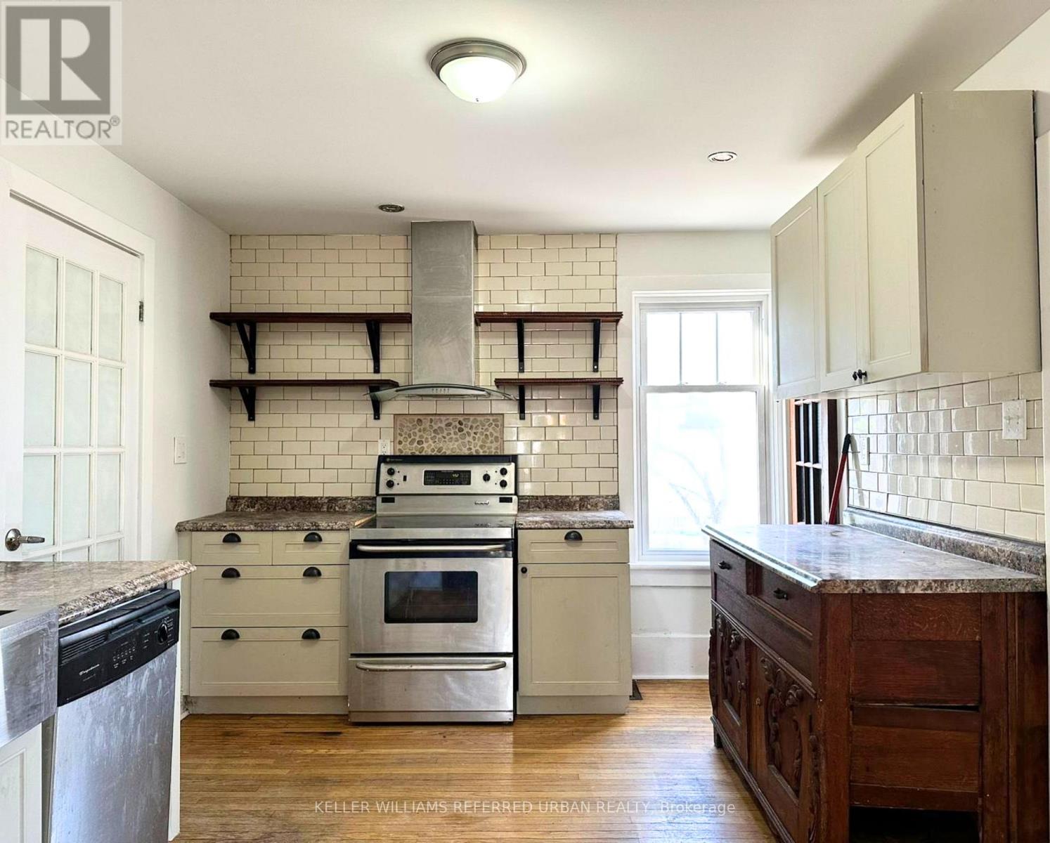 A kitchen with a stove top oven and a range hood.