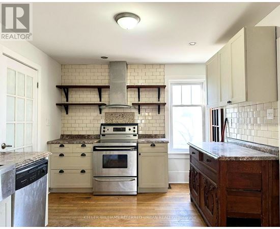 A kitchen with a stove top oven and a range hood.