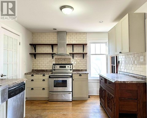 A kitchen with a stove top oven and a range hood.