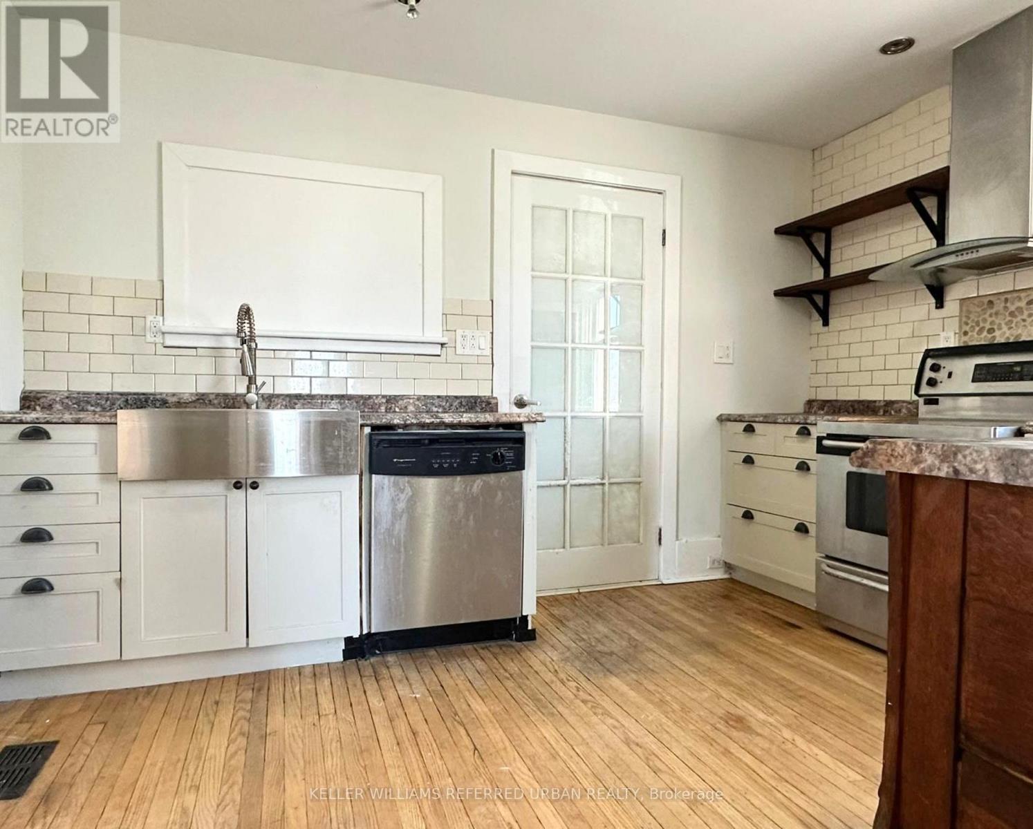 A kitchen with white cabinets and a stainless steel dishwasher.