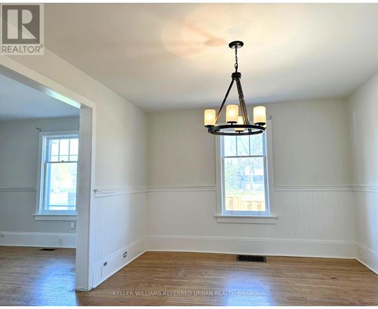 A well-lit room with a chandelier and two windows.